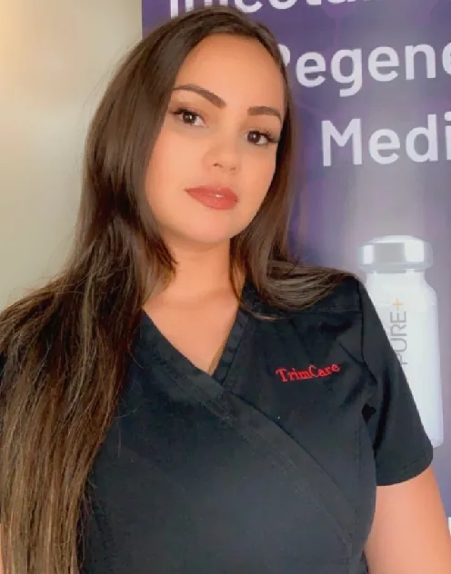 Woman in Black TrimCare Scrubs Standing by a Medical Banner